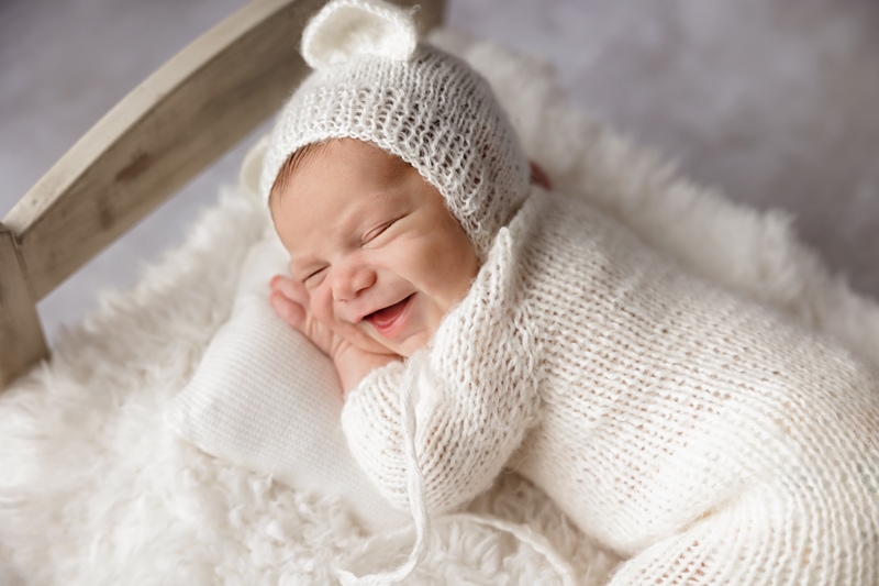 Newborn baby with bear bonnet smiling - Belle Haven Photography